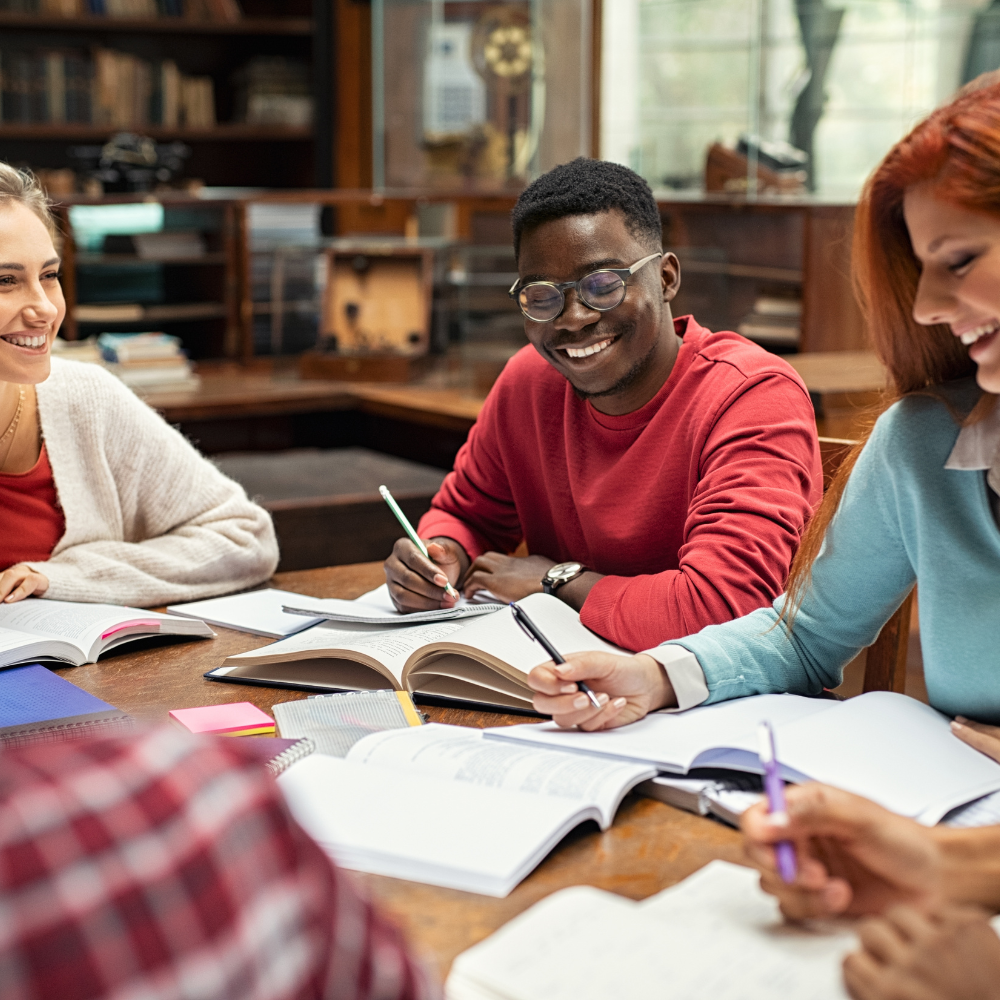 Student smiling and studying at a table.