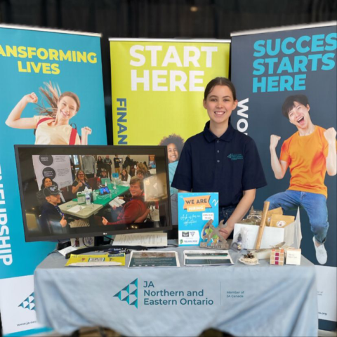 A photo of Leighla at a booth promoting Junior Achievement.