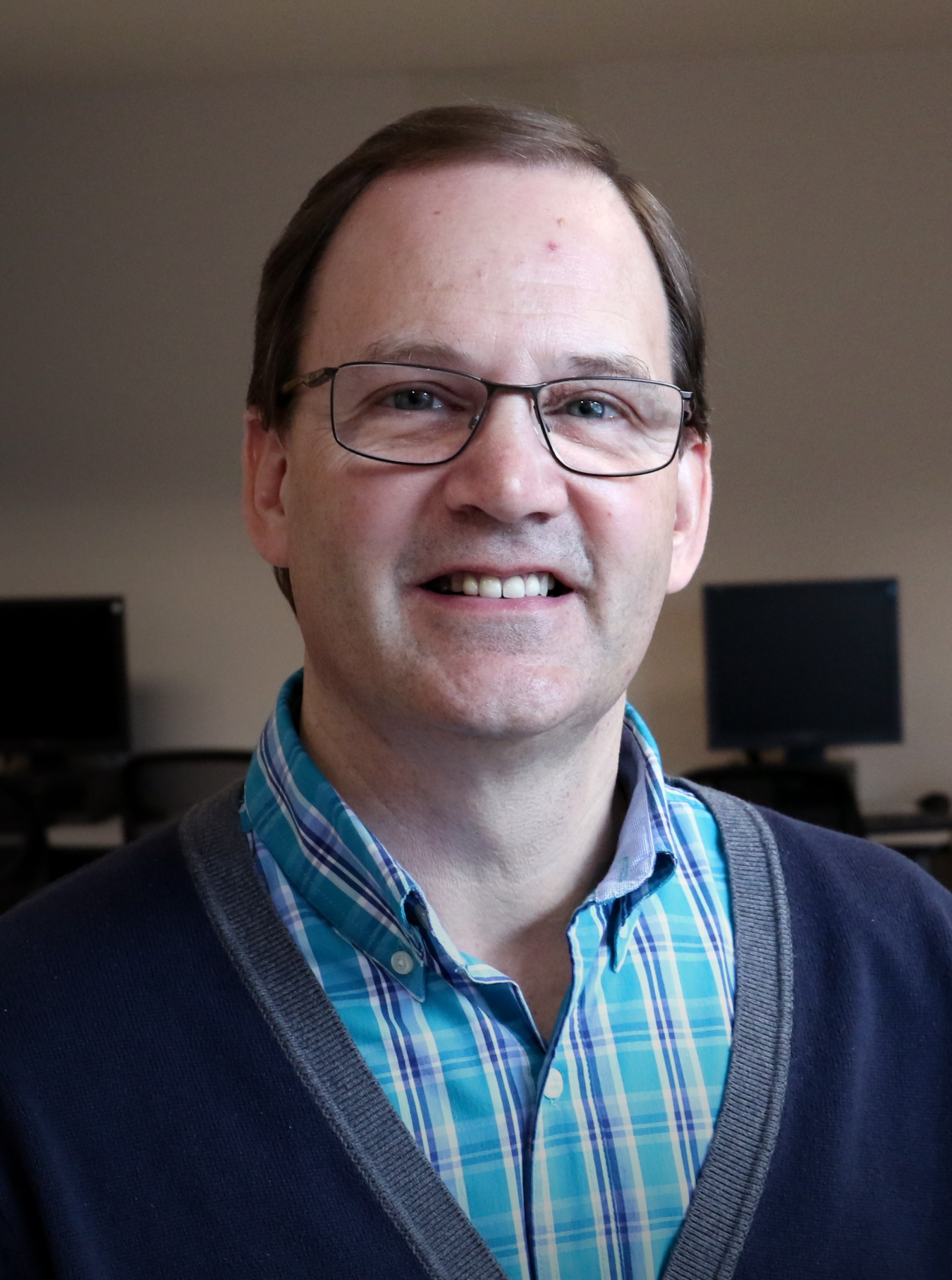 Richard Hurley wearing an orange shirt, looking at the camera