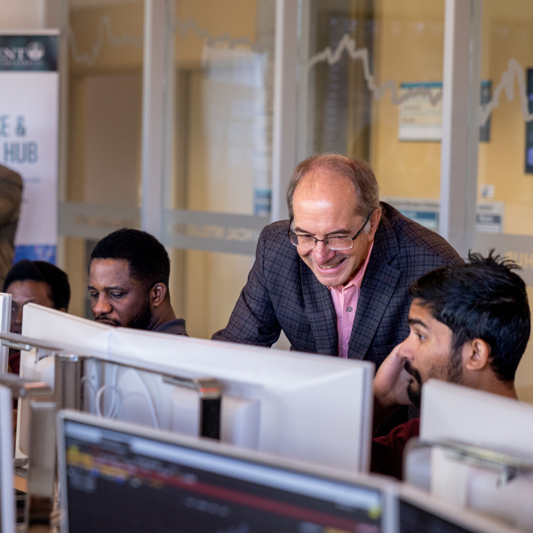 students working with professor in computer lab
