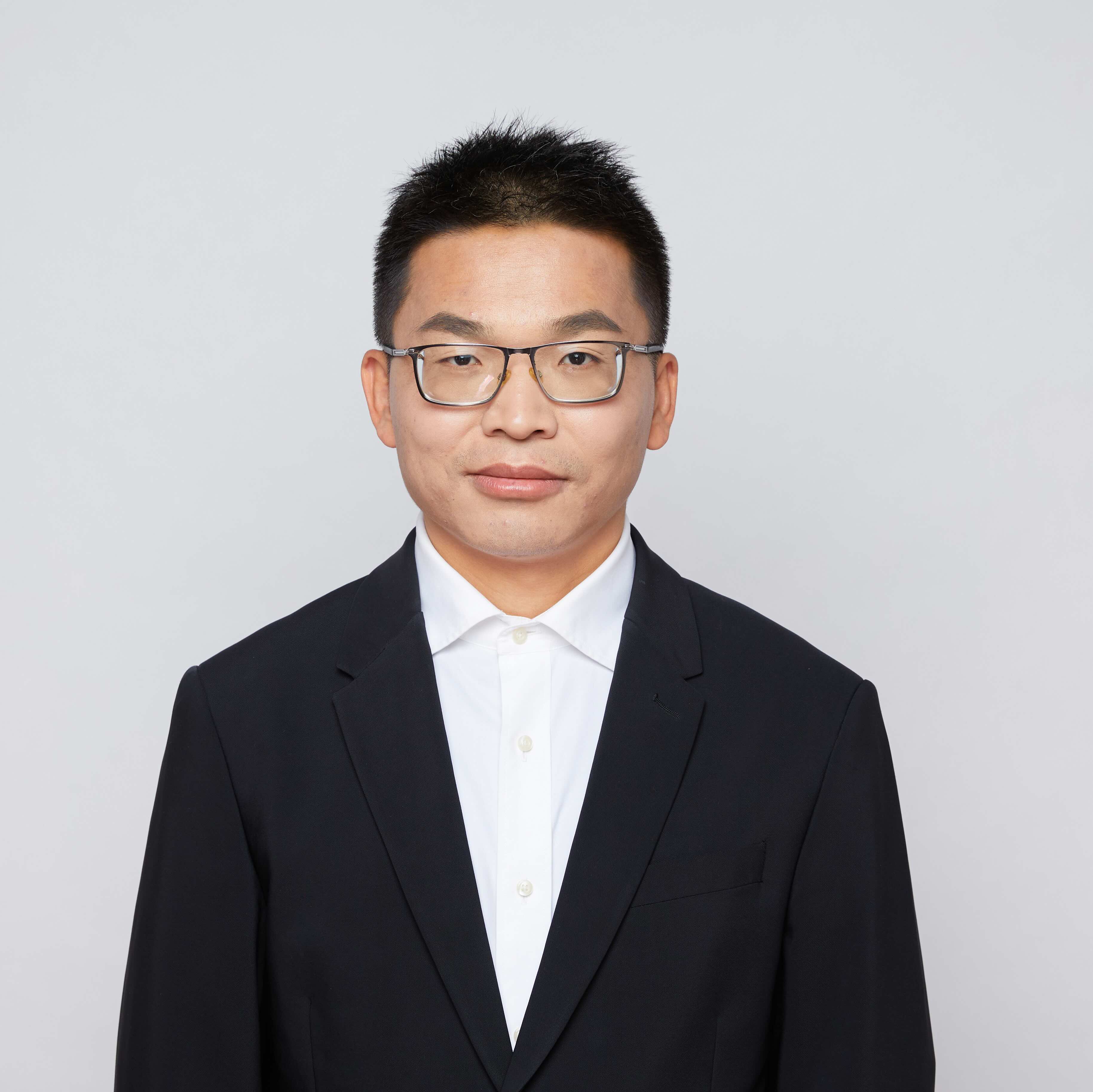  Prof. Guo in a black suit with white dress shirt, looking at camera