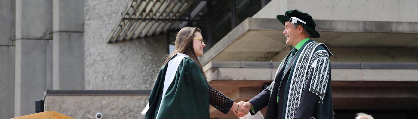President Leo Groarke shaking a girl's hand who is graduating