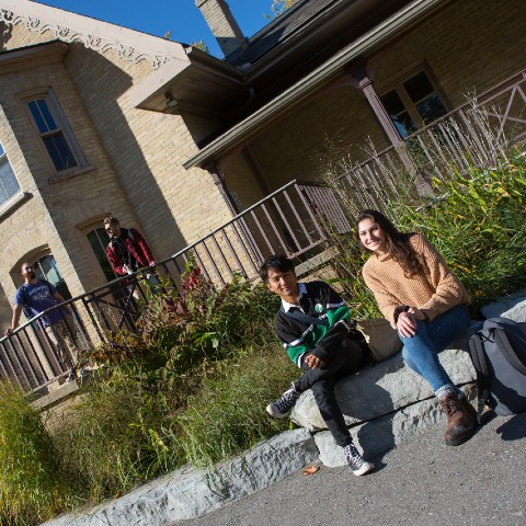 Two pairs of students talking outside of Catharine Parr Traill College.
