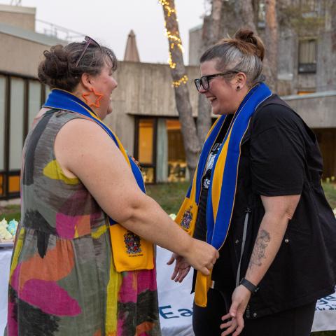 A staff member receiving a scarf as a Lady Eaton fellow