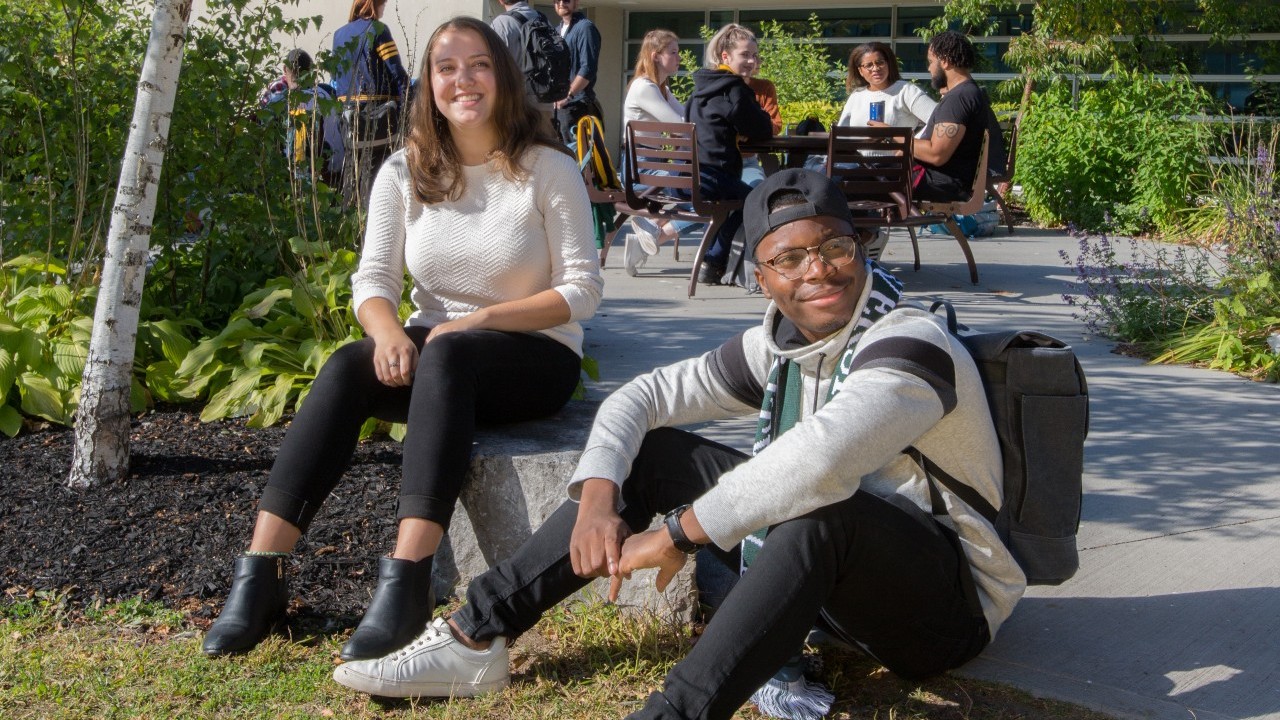 Two students sitting outside at OC