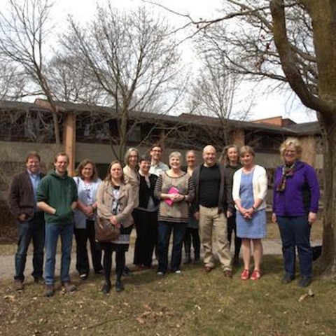 A group of professors standing outside