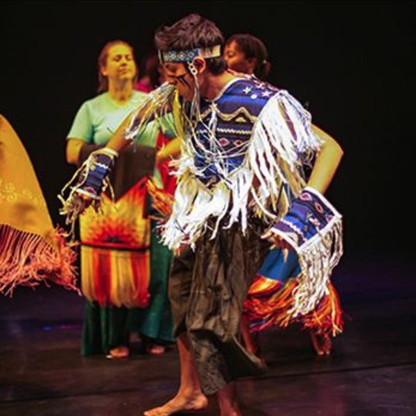 An indigenous student dancing in traditional regalia