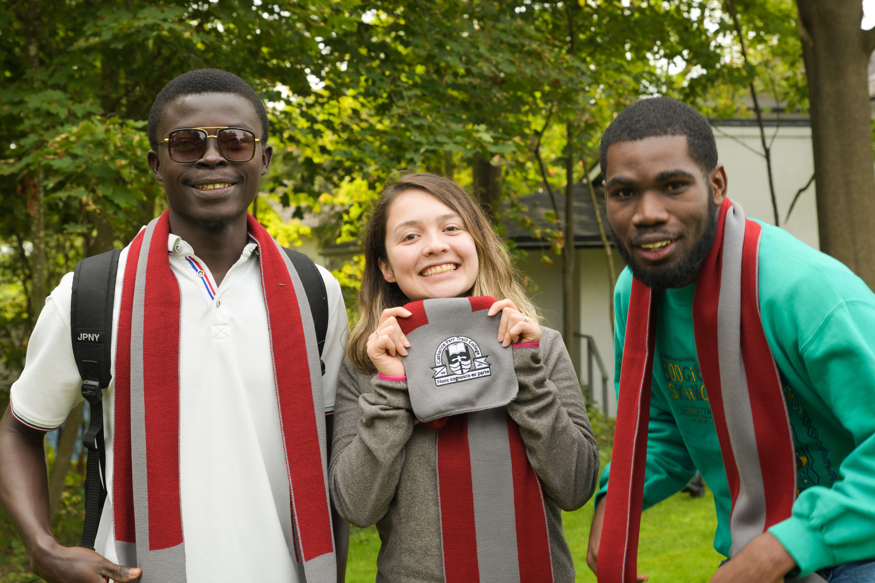 Three students wearing Traill scarves