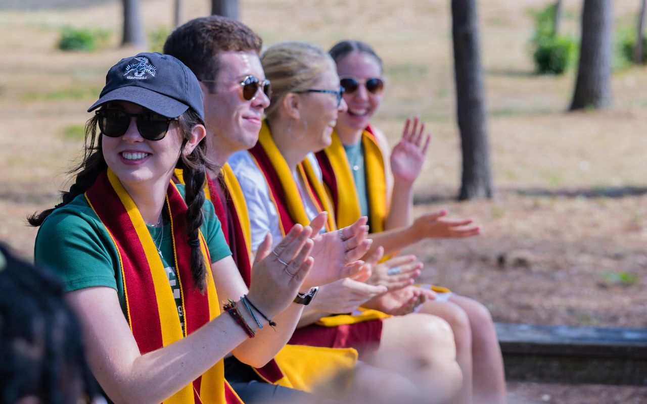 Students wearing yellow scarves clapping