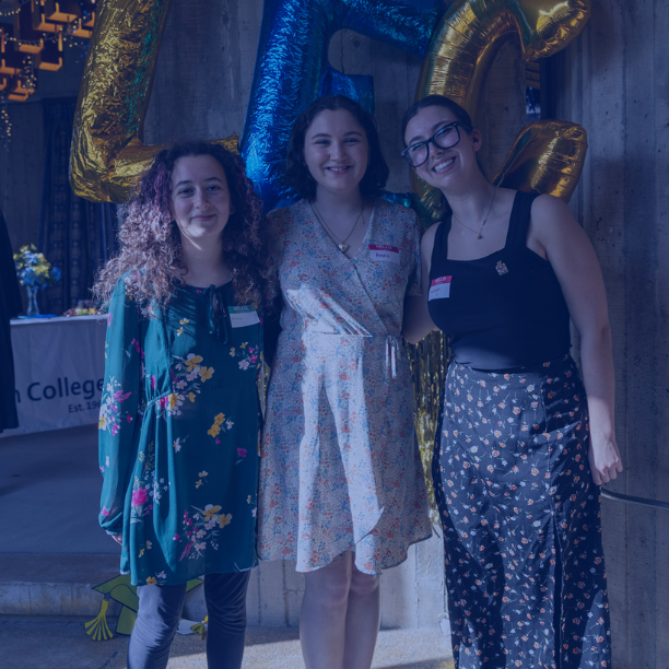 Photo of three students with balloons in background