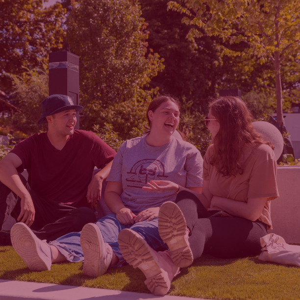 Photo of three students sitting and laughing