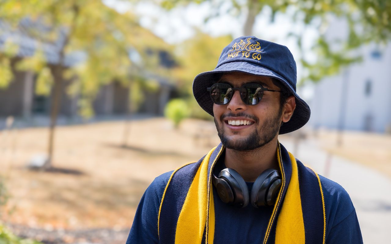 Photo of student wearing hat, scarf, and sunglasses