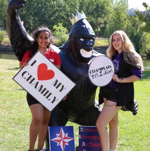 Two Champlain students posing with college's mascot, Pax the Gorilla.