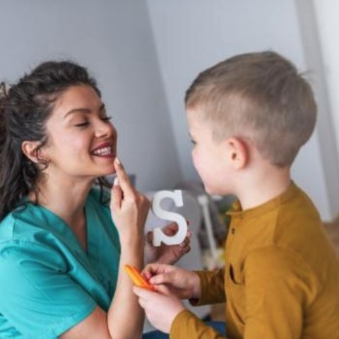 An instructor teaching sign language to a child