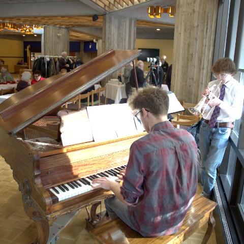 Students playing music together in the Lady Eaton College dining hall
