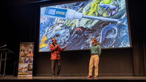 Two people conversing on stage