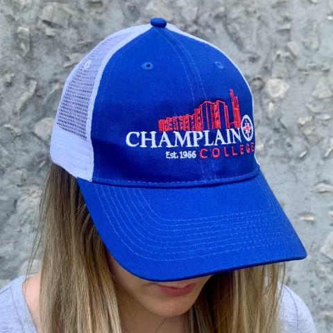 A woman wearing a Champlain College baseball hat.