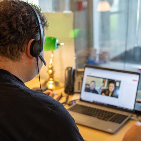 An academic advisor holding a virtual conversation on their laptop.