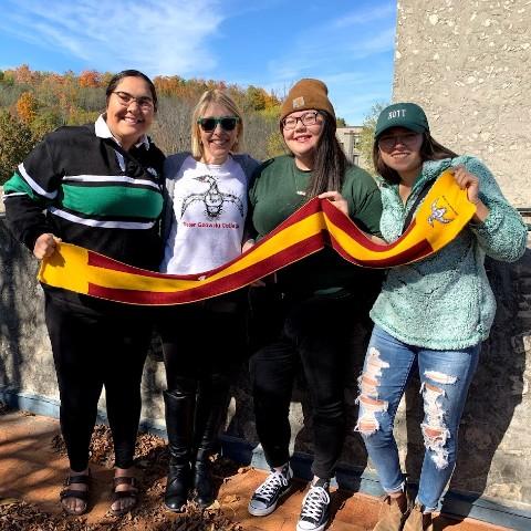 Principal Melanie Buddle and three students with a Gzowski scarf.