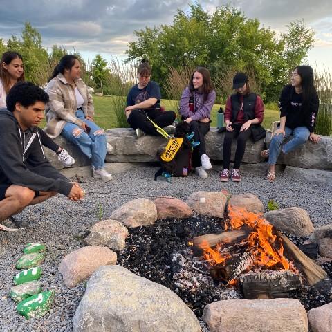 A group of Gzowski students sitting around a campfire