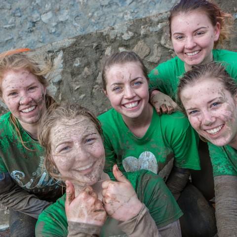 Five female students smiling after competing in the Tough Mudder.