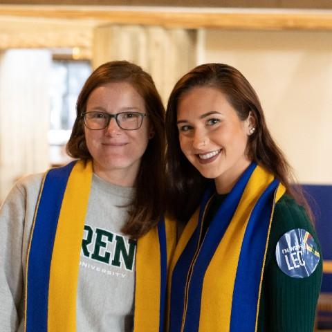 Two women proudly wearing their Lady Eaton College scarves.