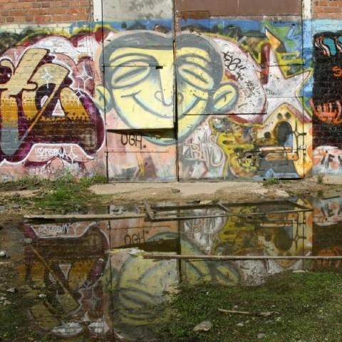 An exterior brick wall covered in graffiti art
