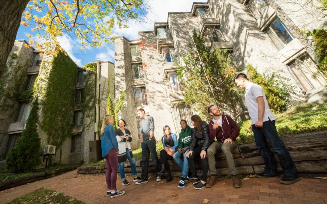 A group of students sitting on a bench outdoors at Champlain College