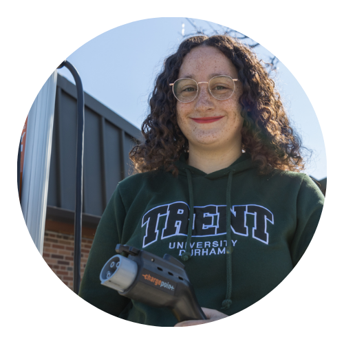 Jade Gauthier, Communications Program student, holding an electric vehicle charger