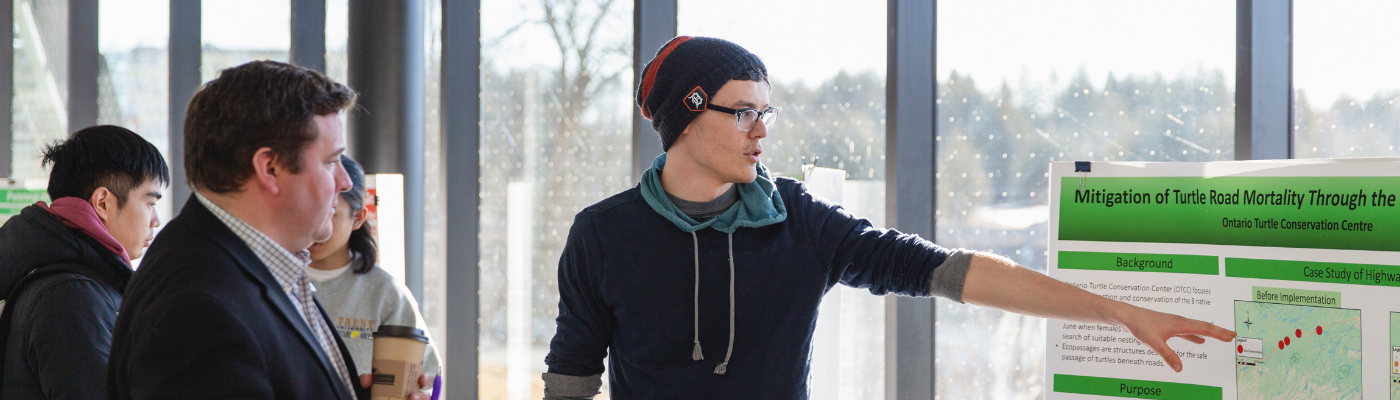 person pointing to a research poster