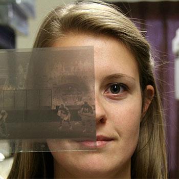 Student holding up a photo negative as part of a community-based research project.