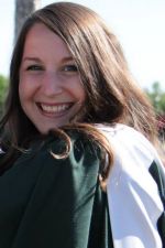 Brittany Gaeten smiling at the camera, wearing a convocation gown and white hood