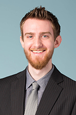 David Shadlock smiling at the camera wearing a gray business suit