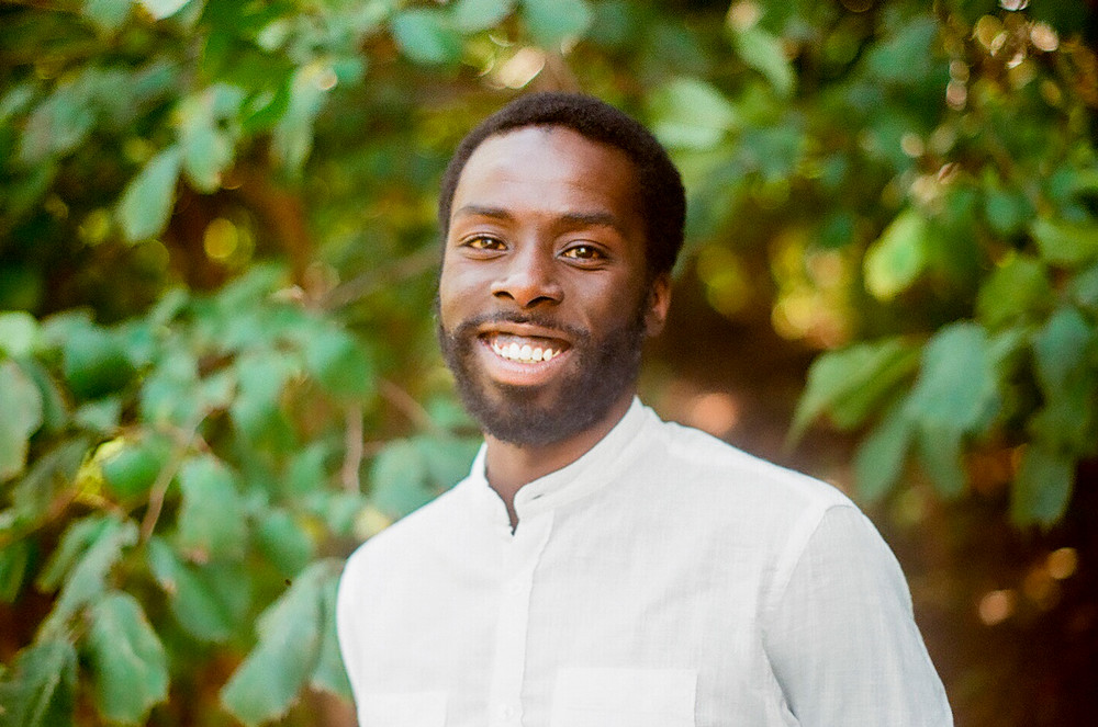A man outside, smiling at the camera