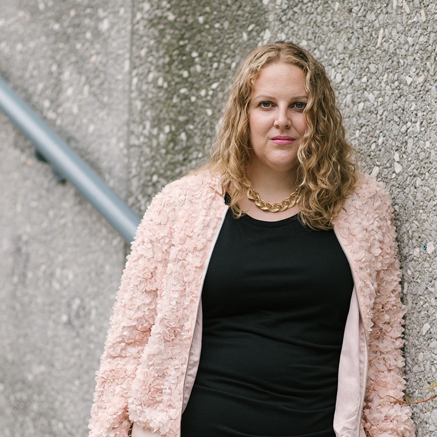 "white woman in black dress and pink jacket"