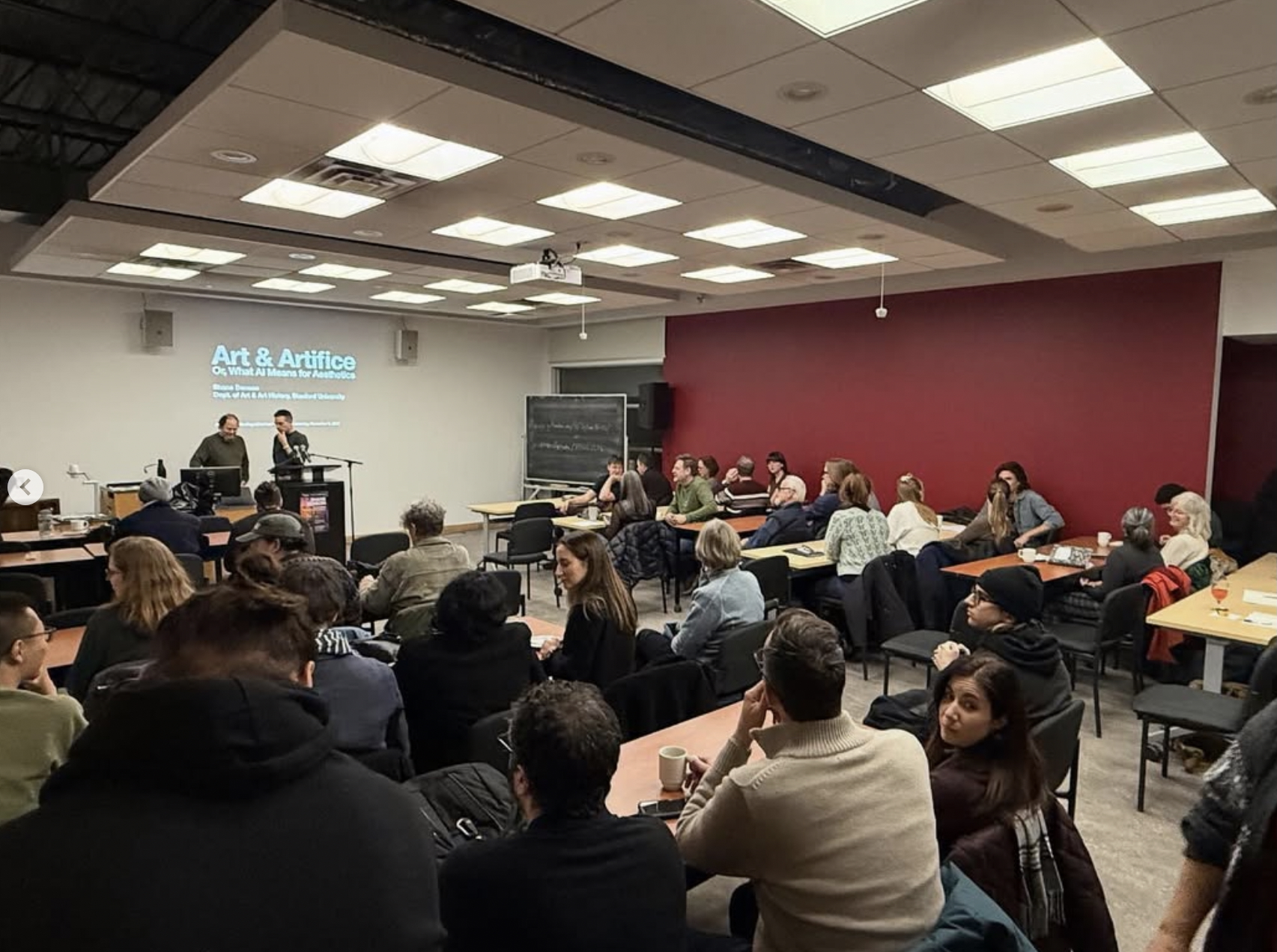 Large group of people gathered in a lecture room to listen to a guest speaker