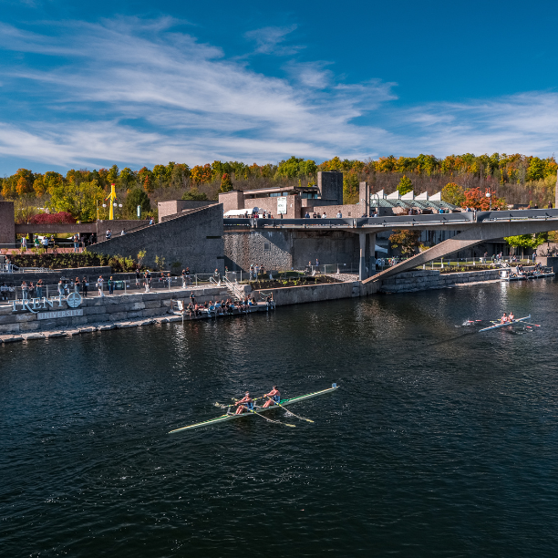 River shot of Trent Symons campus with rowers