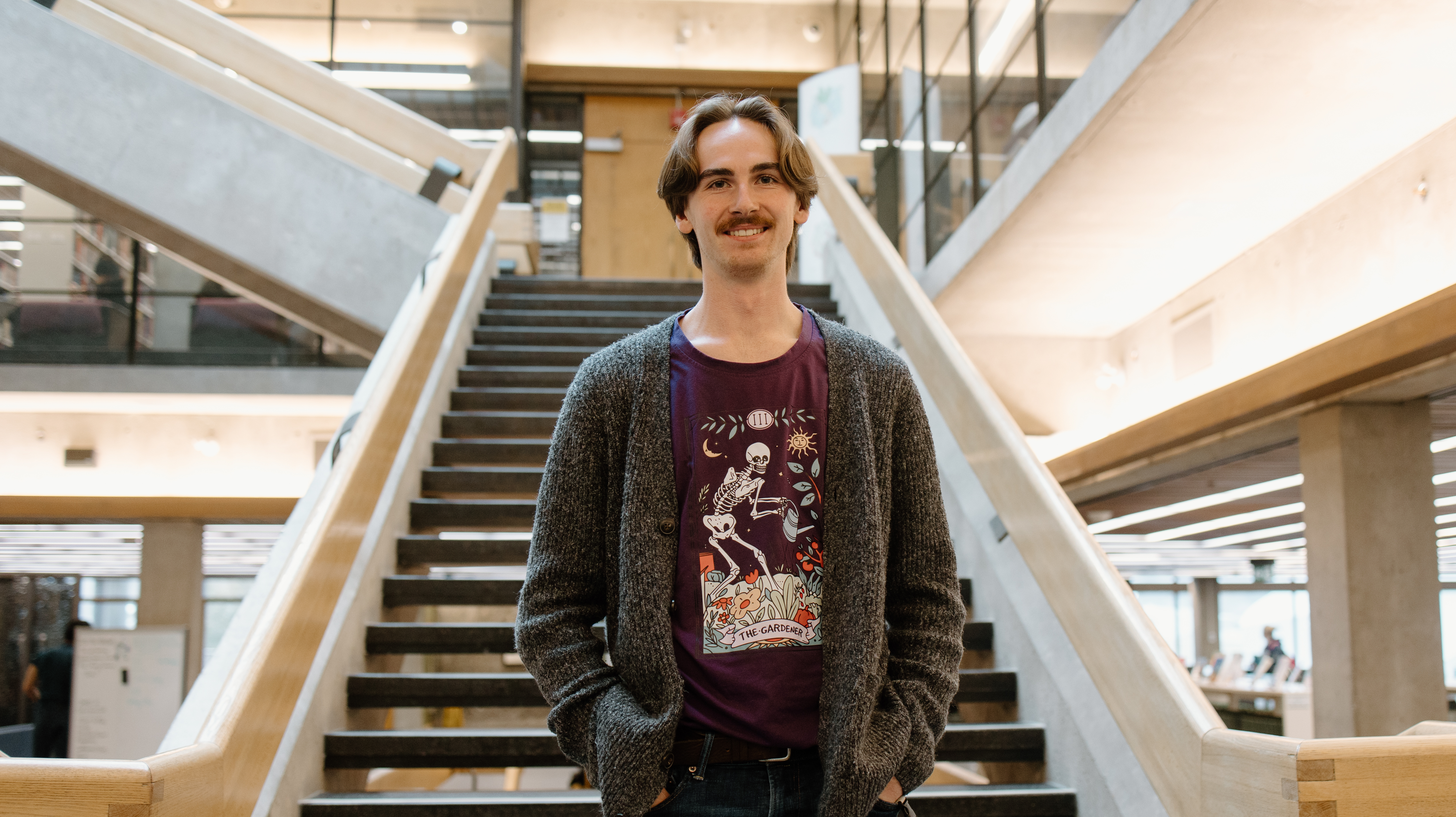 Trent student standing at bottom of library stairs