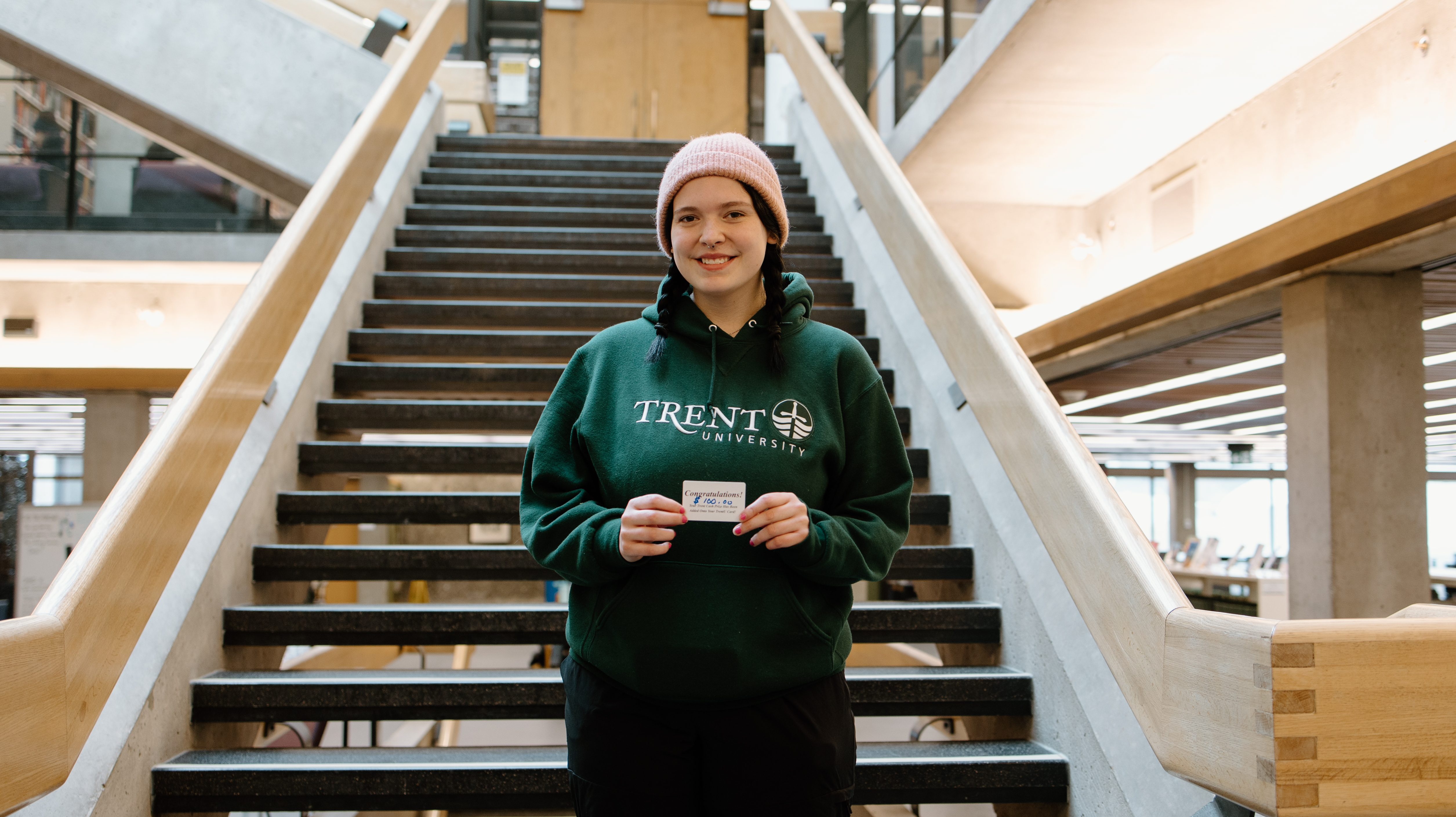 Student holding one hundred dollar Trent cash gift card
