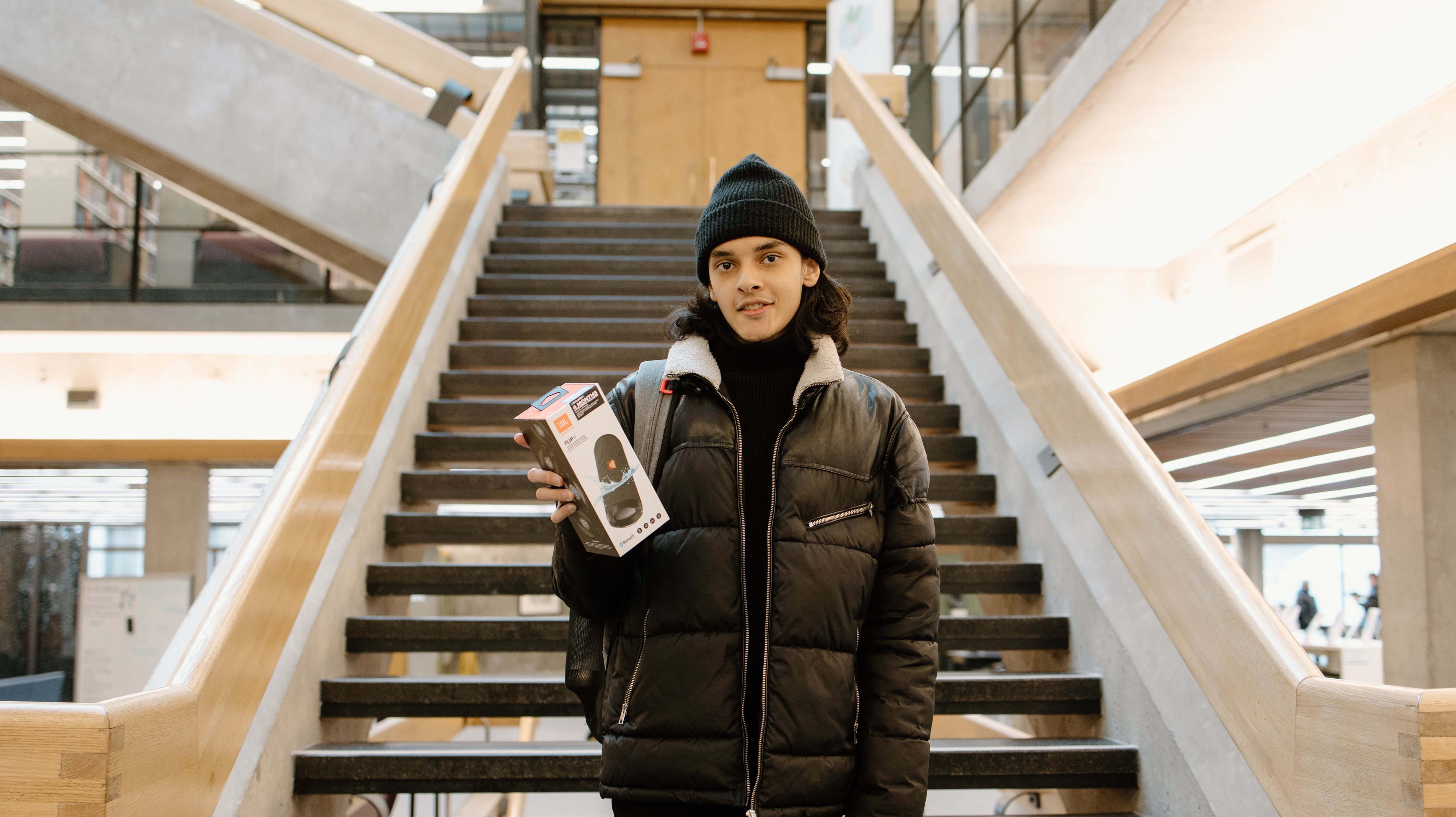 Student holding a FLIP 4 Waterproof Bluetooth speaker