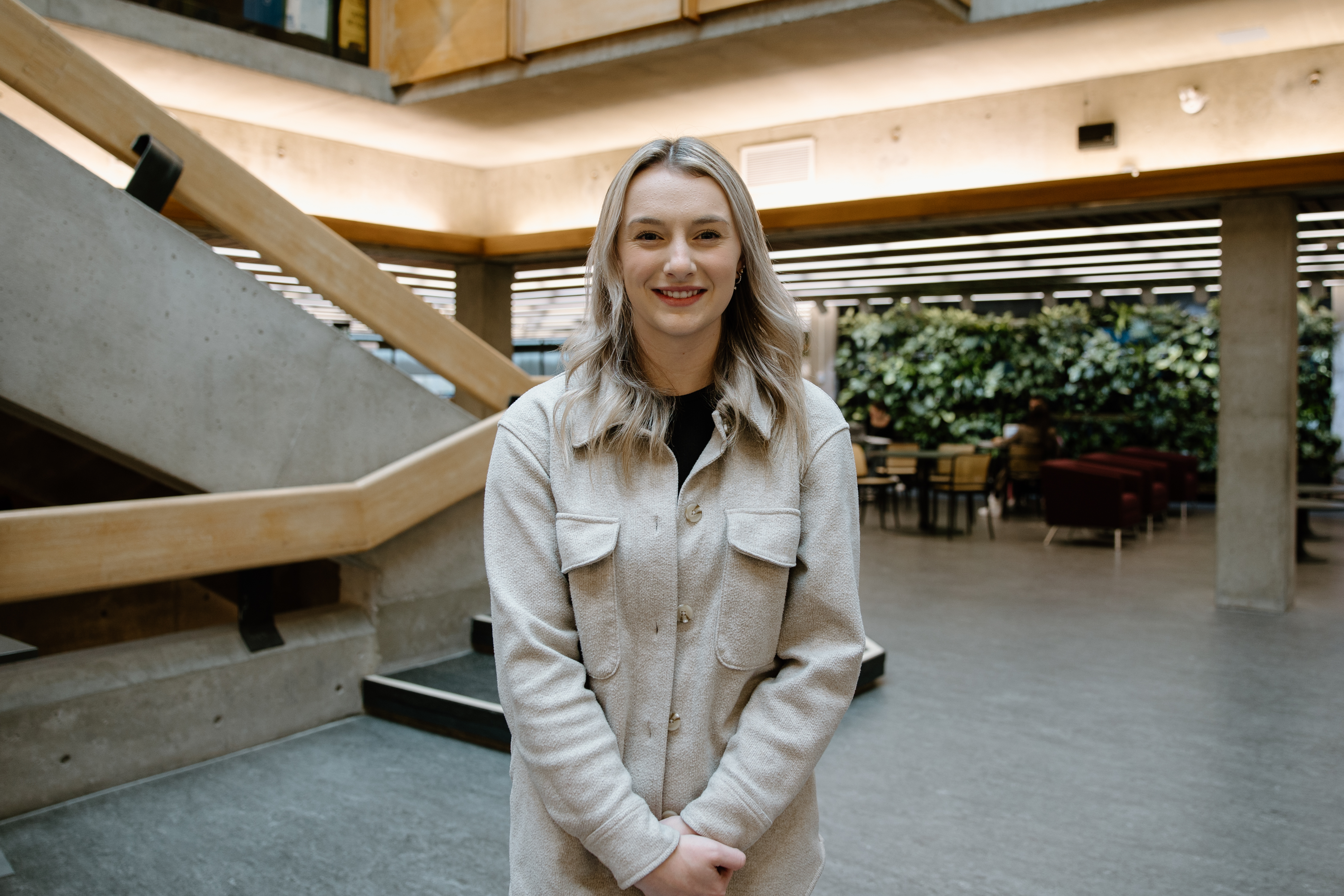 Student standing at the bottom of the library stairs