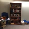 An image of the Multi-Faith Room, which shows a bookshelf, a table, and some prayer mats