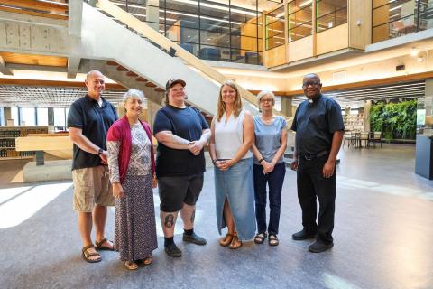 A group of people standing in a large open space, smiling
