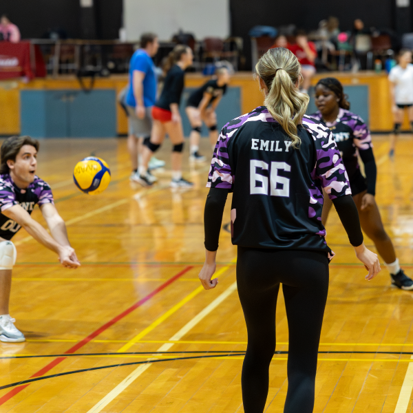 Students playing volleyball in a gym