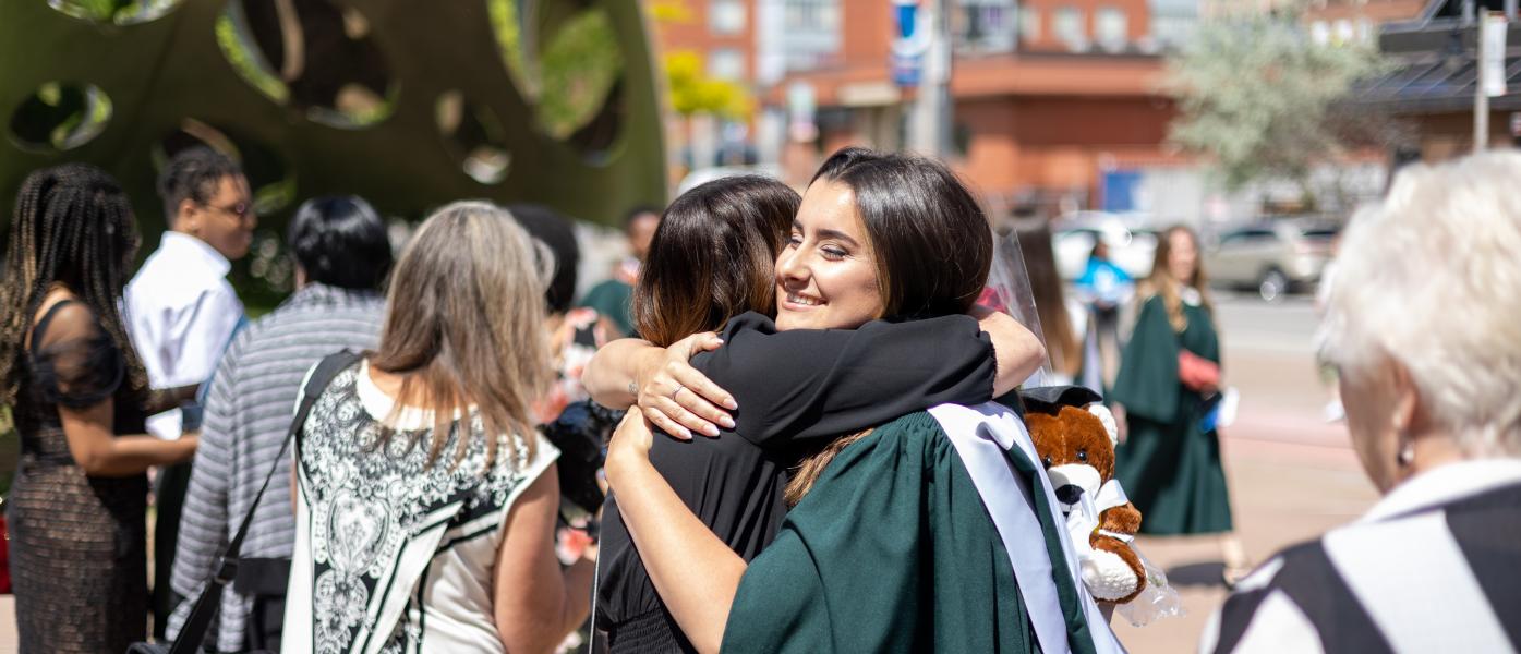 Image of graduate embracing their guest.