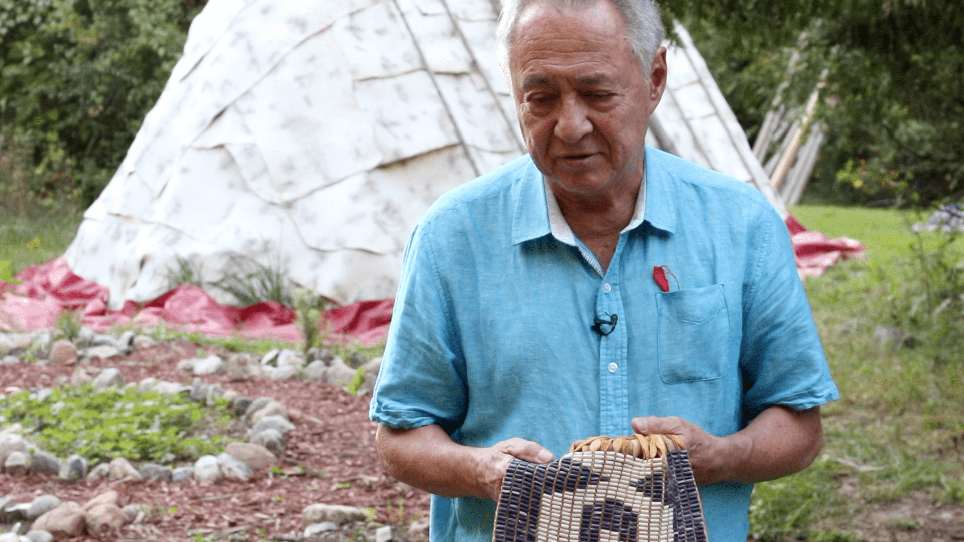 Maurice Switzer holding a wampum belt telling a story about it