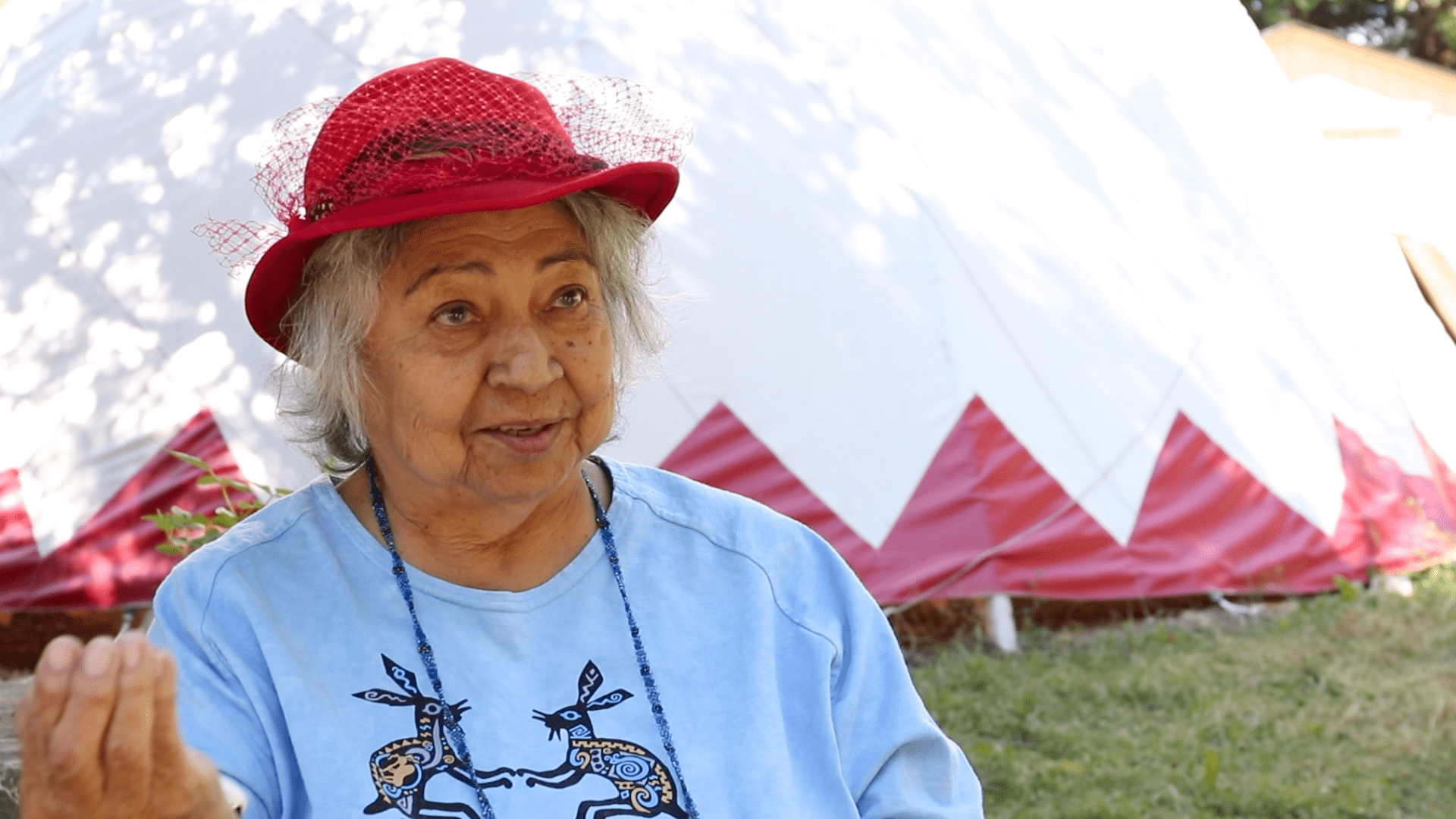 Shirley Williams talking with tipi in the background