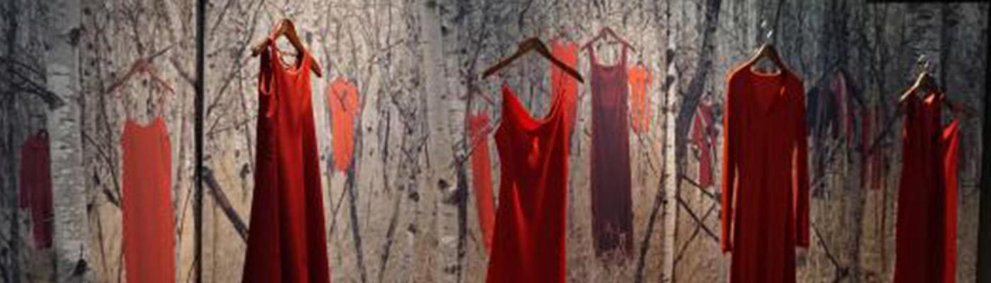 Red dresses hanging up; artwork by Jaime Black