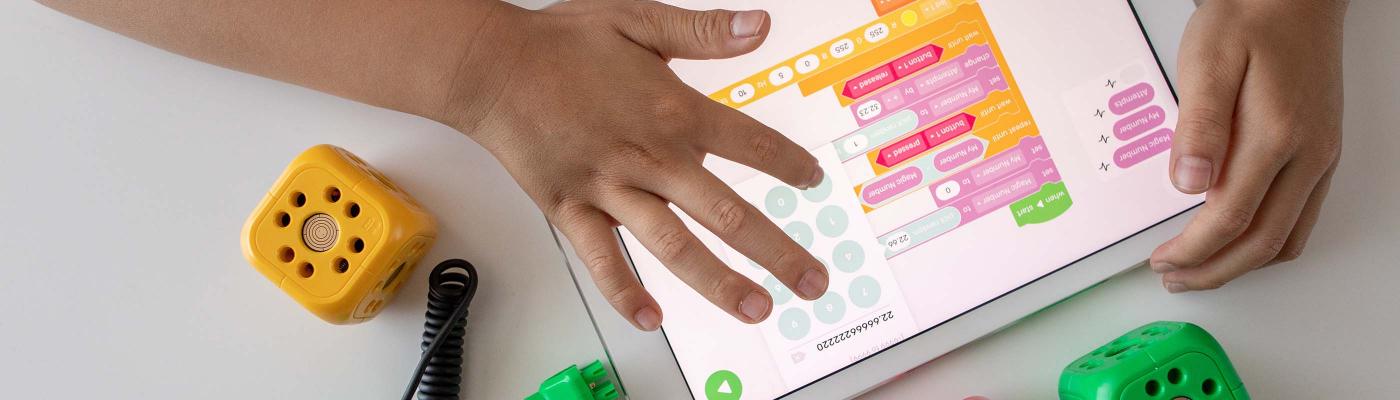 Childs hand on tablet with scratch coding