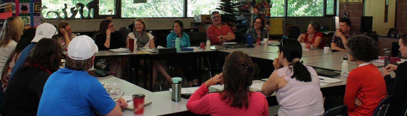 M.Ed. student engaged in discussion at their desks